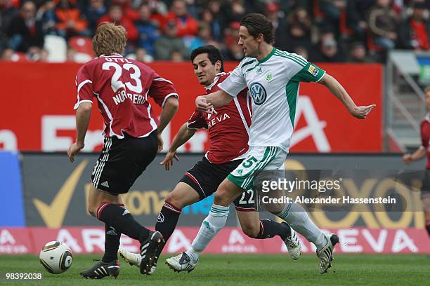 Andreas Ottl of Nuernberg and his team mate Ilkay Guendogan battle for the ball with Christian Gentner of Wolfsburg during the Bundesliga match...