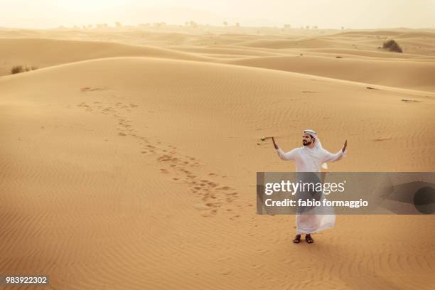 arabic man in the desert - kaftan stock-fotos und bilder