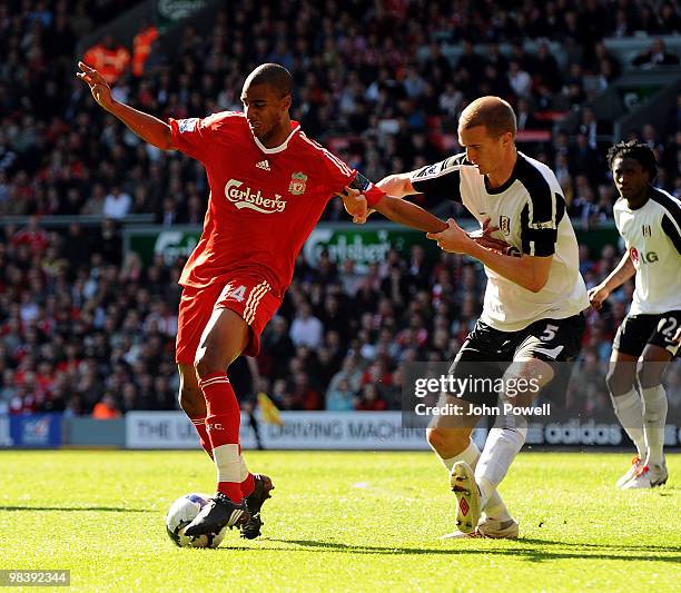 David Ngog of Liverpool competes with Brede Hangeland of Fulham during the Barclays Pemier League match between Liverpool Fulham at Anfield on April...