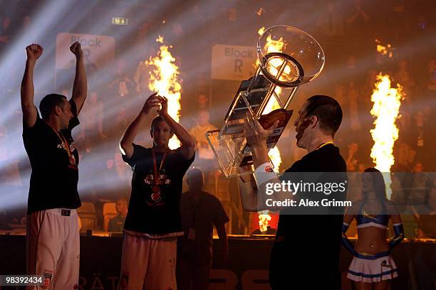 Casey Jacobsen of Brose Baskets Bamberg presents the trophy to his team mates after winning the Beko BBL Top Four basketball tournament against...