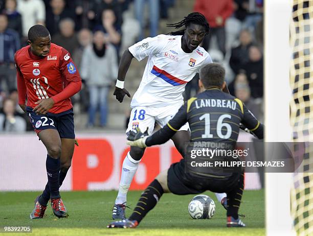 Lyon's French forward Bafetimbi Gomis vies with Lille's French defender Aurelien Chedjou and French goalkeeper Mickael Landreau during their French...