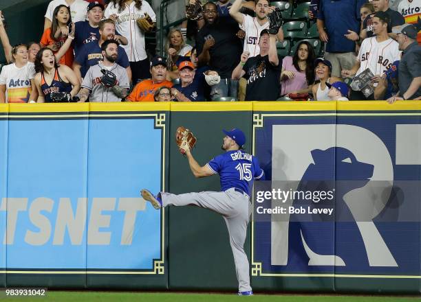Randal Grichuk of the Toronto Blue Jays makes a leaping catch at the wall to take away a three run home run from George Springer of the Houston...