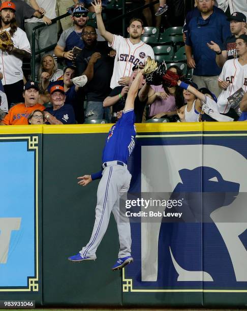 Randal Grichuk of the Toronto Blue Jays makes a leaping catch at the wall to take away a three run home run from George Springer of the Houston...