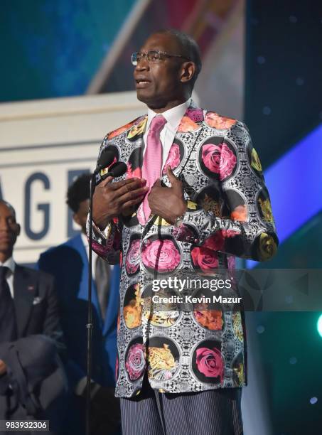 Sager Strong award winner Dikembe Mutombo accepts his jacket from Reggie Miller, Yvonne Orji, and Joel Embiid onstage at the 2018 NBA Awards at...