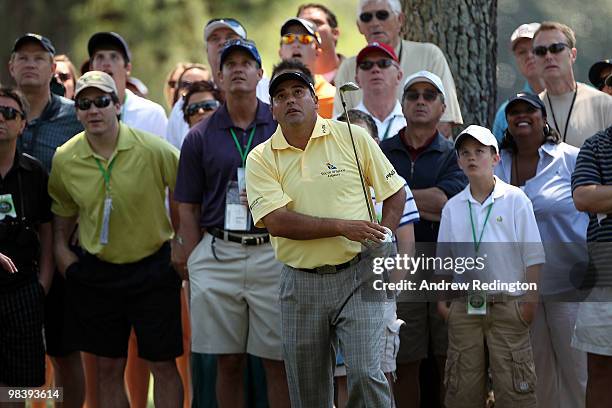 Angel Cabrera of Argentina watches his shot on the first hole in front of a gallery of fans during the final round of the 2010 Masters Tournament at...