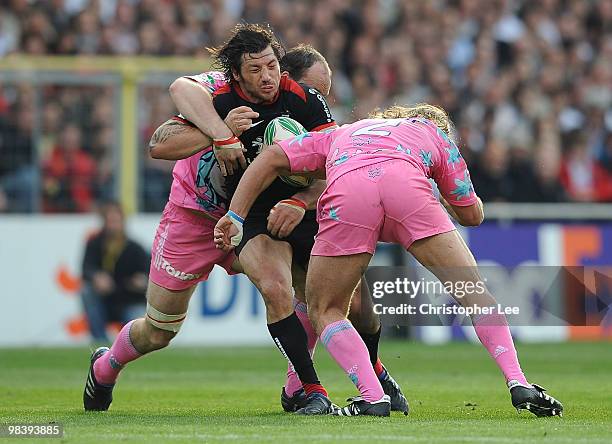 Byron Kelleher of Toulousain is tackled by Antoine Burban and Dimitri Szarzewski of Francais during the Heineken Cup Quarter Final match between...