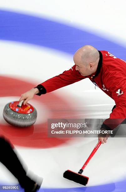 Canada's skipper Kevin Koe shoots the stone during the Men's world curling championship final in Cortina D'Ampezzo on April 11, 2010. Canada won...