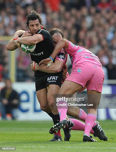 Byron Kelleher of Toulousain is tackled by Antoine Burban and Dimitri Szarzewski of Francais during the Heineken Cup Quarter Final match between...