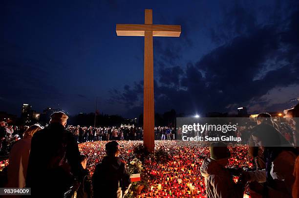 Mourners arrive to light candles under a giant cross at Pilsudski Square in memory of late Polish President Lech Kaczynski on April 11, 2010 in...