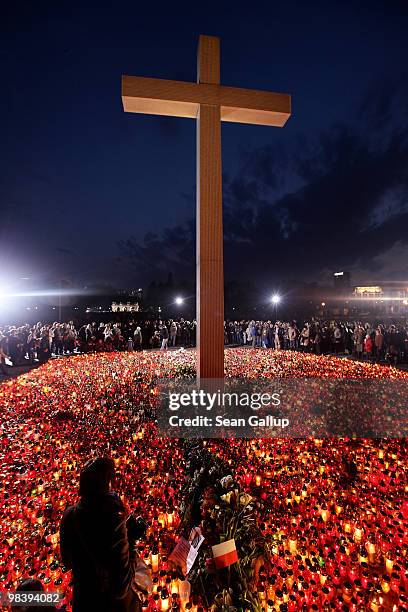 Mourners arrive to light candles under a giant cross at Pilsudski Square in memory of late Polish President Lech Kaczynski on April 11, 2010 in...