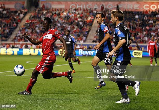 Patrick Nyarko of the Chicago Fire passes the ball under pressure from Bobby Convey and Ramiro Corrales of the San Jose Earthquakes in an MLS match...