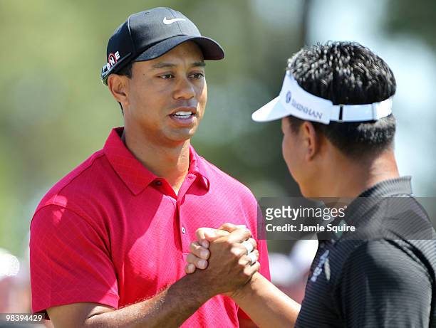 Tiger Woods and K.J. Choi of South Korea shake hands before teeing off on the first hole during the final round of the 2010 Masters Tournament at...