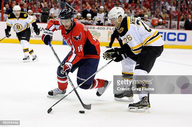 Eric Belanger of the Washington Capitals keeps the puck away from Blake Wheeler of the Boston Bruins at the Verizon Center on April 11, 2010 in...