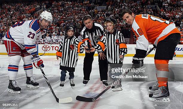 Referee Kerry Fraser is joined by his grandkids for a ceremonial puck drop between Chris Drury of the New York Rangers and Mike Richards of the...