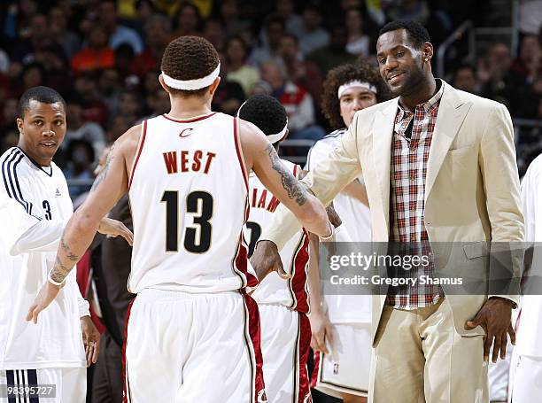 LeBron James of the Cleveland Cavaliers congratulates Delonte West along with Sebastian Telfair while playing the Orlando Magic on April 11, 2010 at...