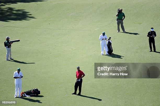 Tiger Woods waits on the ninth fairway with K.J. Choi of South Korea and their caddies during the final round of the 2010 Masters Tournament at...