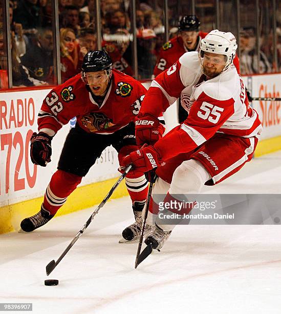 Niklas Kronwall of the Detroit Red Wings battles for the puck with Kris Versteeg of the Chicago Blackhawks at the United Center on April 11, 2010 in...