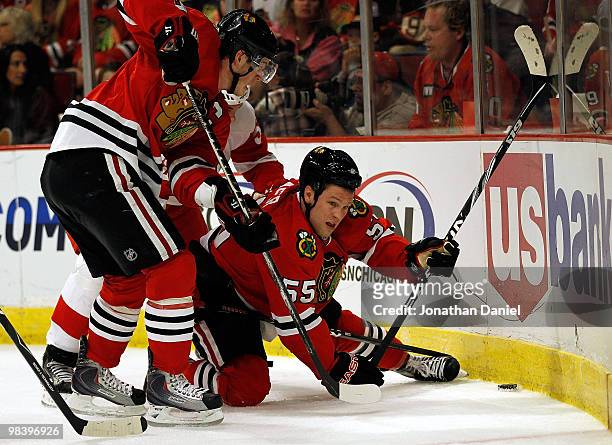 Ben Eager and Jonathan Toews of the Chicago Blackhawks try for the puck in the corner as Toews screens Jonathan Ericsson of the Detroit Red Wings at...