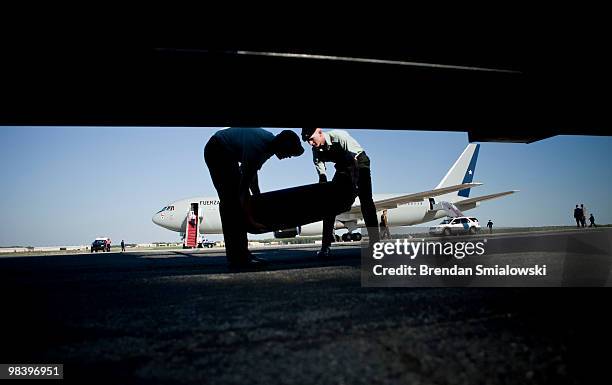 Air Force personnel bring back a rolled up red carpet after Chilean President Sebastian Pinera arrived with his delegation April 11, 2010 at Andrews...