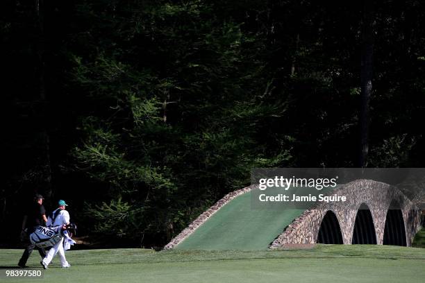 Phil Mickelson and caddie Billy Foster walk to the Hogan Bridge during the final round of the 2010 Masters Tournament at Augusta National Golf Club...