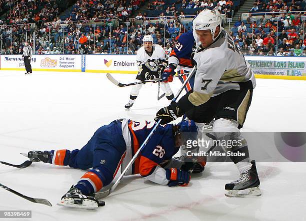 Mark Eaton of the Pittsburgh Penguins attemps to get the puck out from underneath Matt Moulson of the New York Islanders on April 11, 2010 at Nassau...