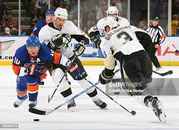 Alex Goligoski and Bill Guerin of the Pittsburgh Penguins battle for a loose puck against Richard Park of the New York Islanders on April 11, 2010 at...