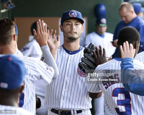 Yu Darvish of the Chicago Cubs gets high fives from his teammates in the dugout after pitching five innings in a minor league rehabilitation start...