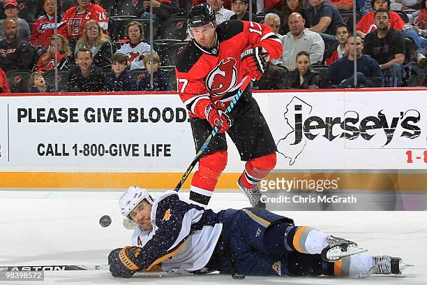 Ilya Kovalchuk of the New Jersey Devils gets a pass away under pressure from Steve Montador of the Buffalo Sabres at the Prudential Center on April...