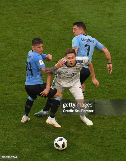 Uruguay players Lucas Torreira and Cristian Rodriguez combine to thwart Russia player Daier Kuziaev during the 2018 FIFA World Cup Russia group A...