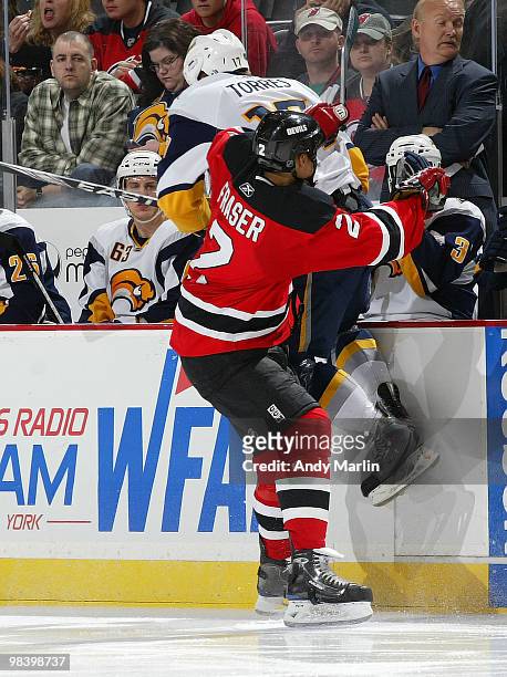 Raffi Torres of the Buffalo Sabres is checked high and hard into the boards by Mark Fraser of the New Jersey Devils during the game at the Prudential...
