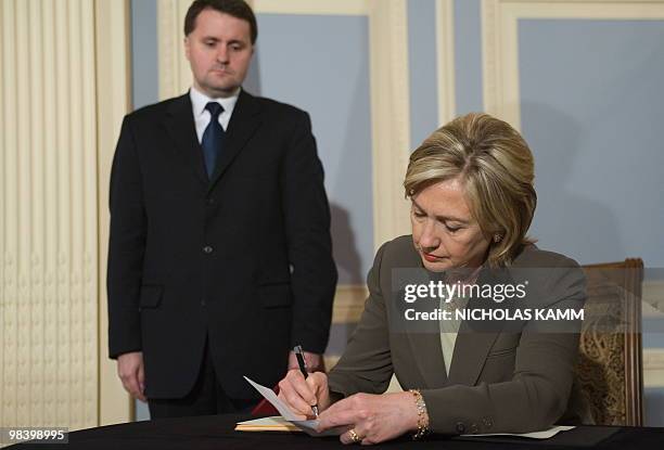 Secretary of State Hillary Clinton signs the condolence book at the Polish Embassy in Washington on April 11, 2010 before Ambassador Robert Kupiecki...