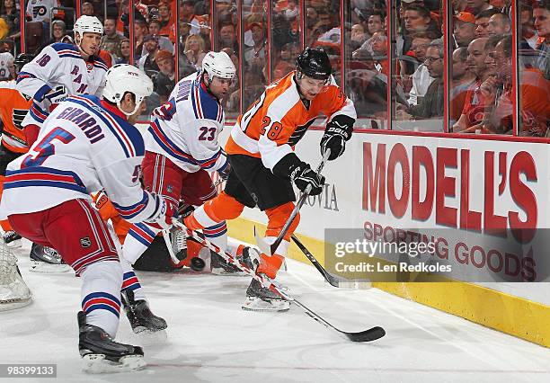 Claude Giroux of the Philadelphia Flyers dumps the puck between Chris Drury and Dan Girardi of the New York Rangers on April 11, 2010 at the Wachovia...