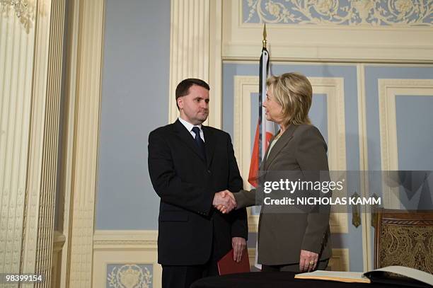 Secretary of State Hillary Clinton shakes hands with Polish Ambassador to the US Robert Kupiecki after signing the condolence book at the Polish...