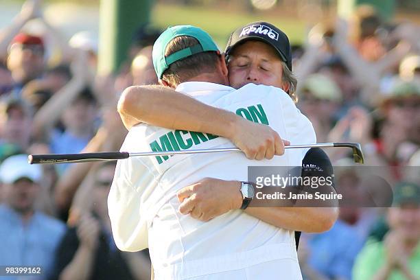 Phil Mickelson hugs his caddie Jim Mackay after his three-stroke victory after winning the 2010 Masters Tournament at Augusta National Golf Club on...