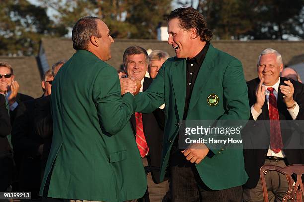 Angel Cabrera of Argentina presents Phil Mickelson with the green jacket during the green jacket presentation after the final round of the 2010...