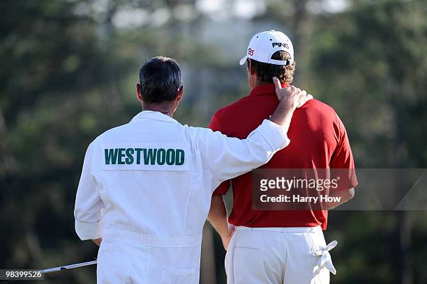 Lee Westwood of England waits with his caddie Billy Foster on the 18th green during the 2010 Masters Tournament at Augusta National Golf Club on...