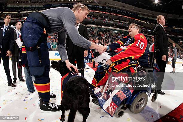 Bryan Allen of the Florida Panthers shakes hands with fan Carol Adams and her dog Lewis after giving her his jersey off his back after the final game...