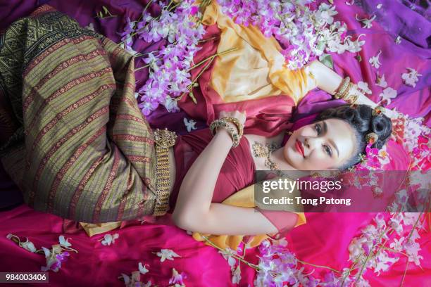 beautiful asian woman with thai traditional dress on orchid flow - chinese opera in thailand stock pictures, royalty-free photos & images