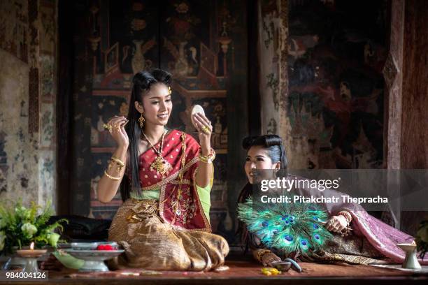 a young woman wearing traditional thai dress. she was combing her hair beautifully and having a... - bainian stock pictures, royalty-free photos & images