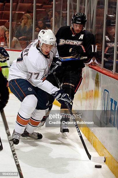 Corey Perry of the Anaheim Ducks defends alongside the boards against Tom Gilbert of the Edmonton Oilers during the game on April 11, 2010 at Honda...