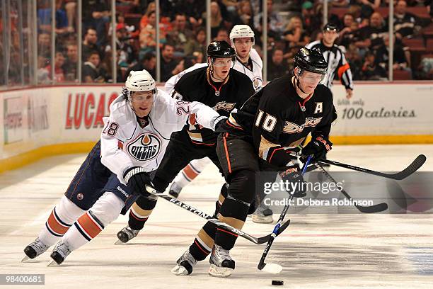 Corey Perry of the Anaheim Ducks handles the puck against Ethan Moreau of the Edmonton Oilers during the game on April 11, 2010 at Honda Center in...