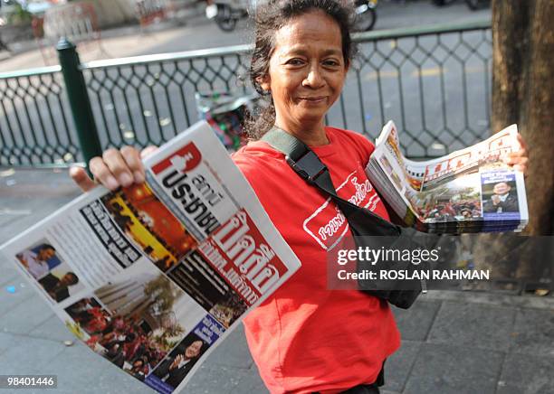 Newspaper vendor and "Red Shirt" supporter shows the front page of the newspaper at a rally site in central Bangkok on April 12, 2010. Tensions...