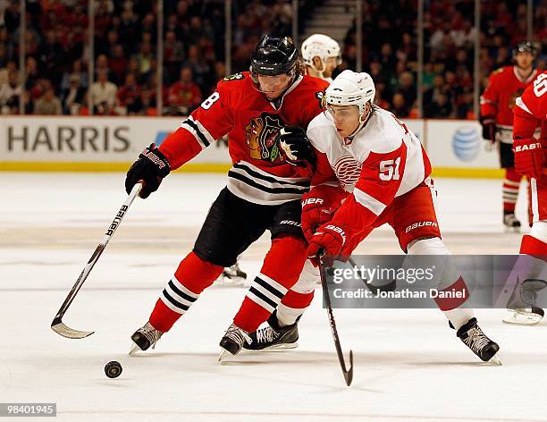 Patrick Kane of the Chicago Blackhawks tries to control the puck against Valtteri Filppula of the Detroit Red Wings applies defensive pressure at the...