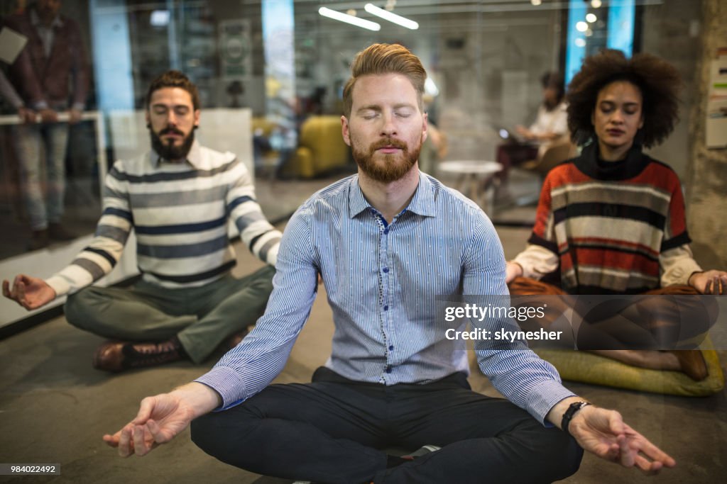 Equipe de pessoas de negócios descontraído exercício Yoga no escritório casual.