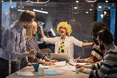 Playful businesswoman making a clown of herself on a meeting in the office.