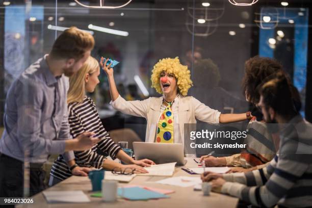 playful businesswoman making a clown of herself on a meeting in the office. - joker stock pictures, royalty-free photos & images