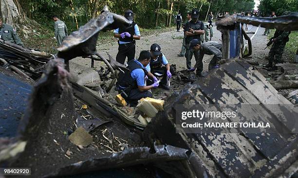 This photo taken on April 11, 2010 shows Thai bomb squad members inspecting the site of a car bomb attack planted by suspected separatist insurgents...