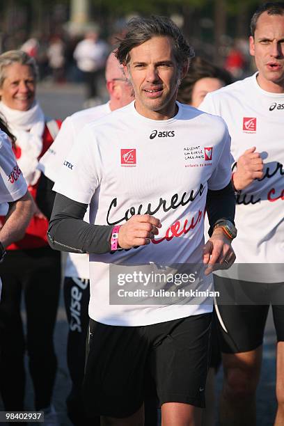 Paul Belmondo and Louis Laforge run for the 'Mecenat Chirurgie Cardiaque' association during the Paris marathon on April 11, 2010 in Paris, France.