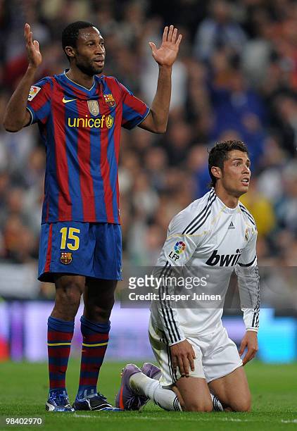 Cristiano Ronaldo of Real Madrid sits on his knees after being fouled flanked by Seydou Keita of FC Barcelona during the La Liga match between Real...