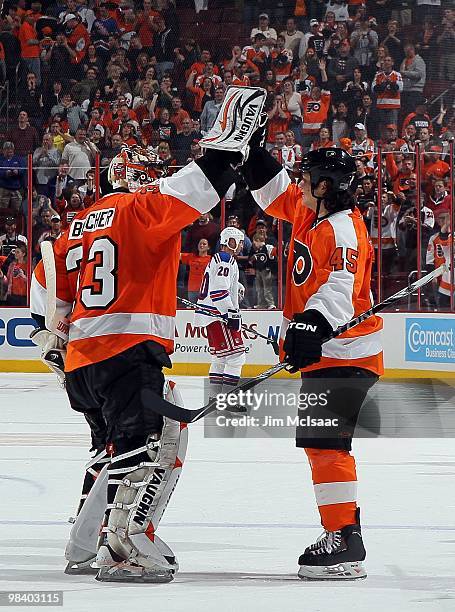 Brian Boucher and Arron Asham of the Philadelphia Flyers celebrate as Vinny Prospal of the New York Rangers skates off the ice on April 11, 2010 at...